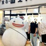 山之内時計眼鏡店の店頭に立つシマバランと笑顔の人々